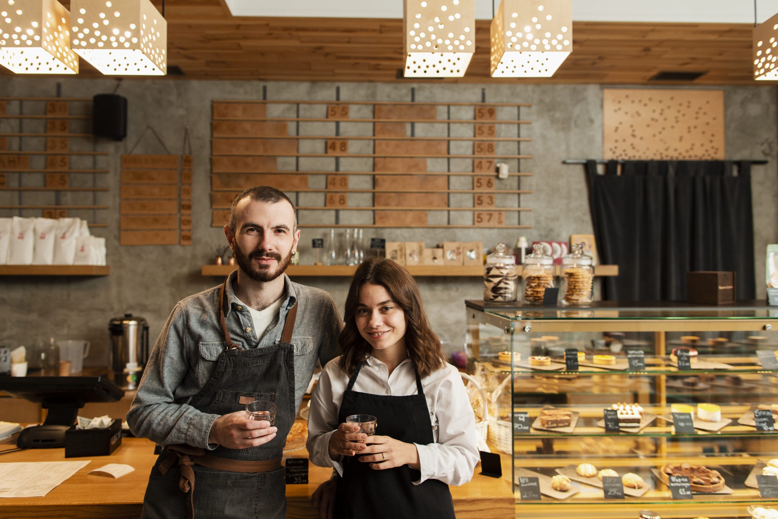 Small business owners organizing receipts and coffee cups, symbolizing bookkeeping and tax preparation.