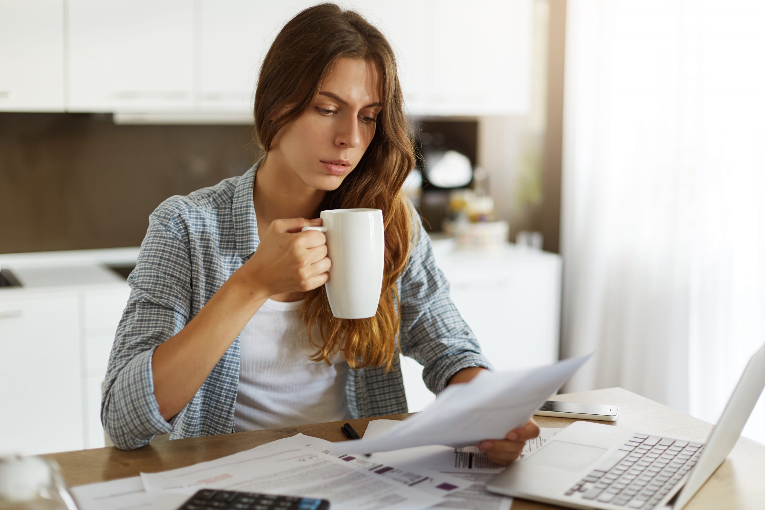 Young woman checking budget and doing taxes at a desk.