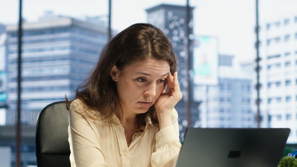 Business owner feeling overwhelmed while reviewing financial information during tax season