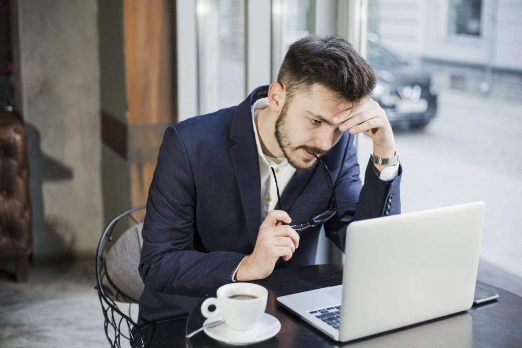 Business owner reviewing financial projections on a laptop while evaluating tax strategy and advisory support